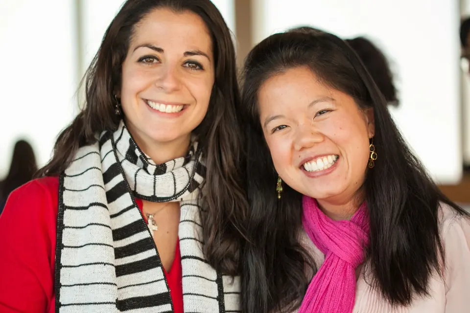 Two smiling colleagues in scarves
